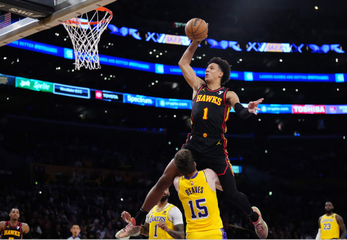 Mar 18, 2024; Los Angeles, California, USA; Atlanta Hawks forward Jalen Johnson (1) dunks the ball over Los Angeles Lakers guard Austin Reaves (15) in the first half at Crypto.com Arena. Mandatory Credit: Kirby Lee-USA TODAY Sports